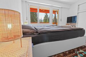- une chambre avec un grand lit et une fenêtre dans l'établissement Studio paisible et chaleureux, à Crans-Montana