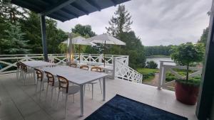 a patio with tables and chairs and a view of a river at Willa Gowidlina in Gowidlino