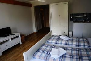 1 dormitorio con 2 camas, TV y escritorio en Pension Scharfe Ecke, en Görlitz