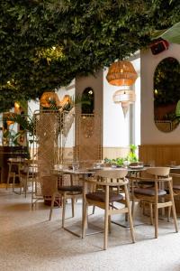een restaurant met tafels, stoelen en planten bij Verno House in Boedapest