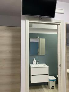 ein Bad mit einem Waschbecken und einem TV an der Wand in der Unterkunft La casa dell’Aurora in Falcone