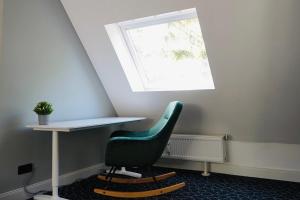 una sedia verde seduta sotto una scrivania in una stanza di Maisonettewohnung in TOP Lage a Wolfsburg