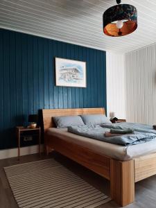 een slaapkamer met een bed en een blauwe muur bij Annemarie Zerpenschleuse - Schwedenhaus mit Künstler-Charme und Sauna in Zerpenschleuse
