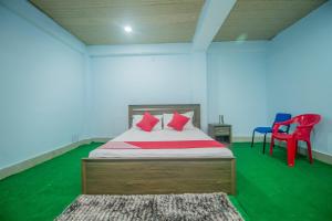 a bedroom with a bed with red and blue chairs at OYO Brikcha Mukhia Home Stay in Pelling