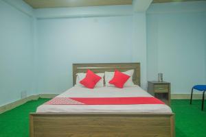 ein Schlafzimmer mit einem Bett mit roten Kissen in der Unterkunft OYO Brikcha Mukhia Home Stay in Pelling