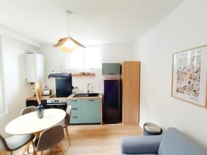 un salon avec une table et une cuisine dans l'établissement Cosy Perle - T3 - Quartier des halles & Parking souterrain, à Pau