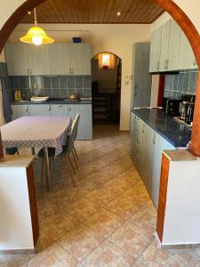 a kitchen with a table and a dining room at House Damado Deluxe in Öttevény