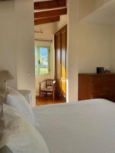 1 dormitorio con 1 cama, 1 silla y 1 ventana en Villa familiar en la montaña, con acceso a piscina, en Denia