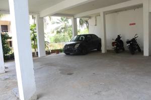 un garaje con dos motos y un coche aparcado en él en Shree SaiRenu near maruthamalai and bharathiyar univ and on the way to Adiyogi Isha Yoga centre, en Marudhamalai