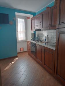 a kitchen with wooden cabinets and a wooden floor at B&B A TAVERNA in Lauria