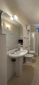 een badkamer met een wastafel, een toilet en een spiegel bij Casa Vacanze Primavera in Maratea