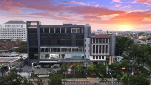 a large office building with a sunset in the background at Luxury Inn Arion Hotel in Jakarta