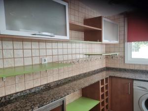 una cocina con estanterías verdes y fregadero en doree 204, en Miami Platja