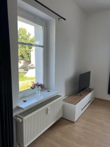 a white room with a window and a television at Apartment 2 - Haus Lausitzring in Annahütte