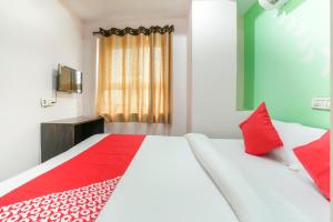 a bedroom with a large bed with red pillows at SPOT ON Hotel Sunshine Inn in Hyderabad