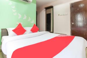 a bedroom with a red and white bed with red pillows at SPOT ON Hotel Sunshine Inn in Hyderabad