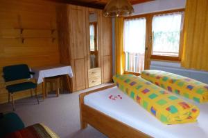 een kamer met een bed, een tafel en ramen bij Haus Salzmann in Sankt Gallenkirch