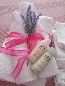 two bottles of face moisturizers on towels with a pink ribbon at B&B A TAVERNA in Lauria