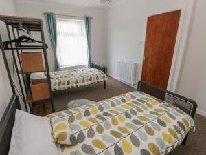 1 dormitorio con cama, escalera y espejo en Brynawel en Burry Port