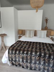 een slaapkamer met een bed met een zwart-witte deken bij Vakantieverblijf Hof Ter Lucht in Petegem