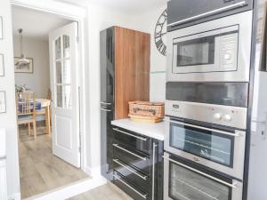 a kitchen with two ovens and a microwave at Branwen in Talacre