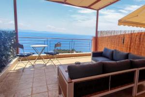 un soggiorno con un divano e un tavolo su un balcone di Simply Meraki Gytheian apt with Panoramic Sea View a Gythio