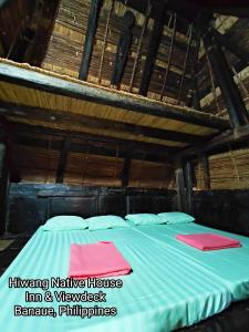Hiwang Native House Inn & Viewdeck في بناو: غرفة نوم مع سرير في منزل من الخيزران