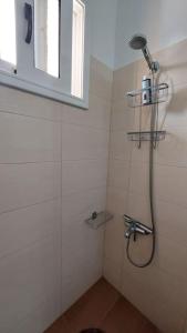 a bathroom with a shower with a shower head at Simply Meraki Gytheian apt with Panoramic Sea View in Gythio
