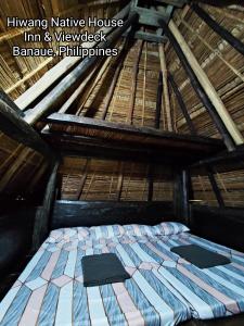 Hiwang Native House Inn & Viewdeck في بناو: سرير كبير في غرفة مع سقف