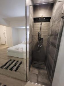 uma casa de banho com chuveiro e uma cama num quarto em Apartment Near The Center Of Glyfada em Atenas