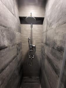 a shower in a bathroom with a stone wall at Apartment Near The Center Of Glyfada in Athens