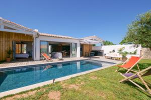 a backyard with a swimming pool and a house at Villa d'architecte avec Piscine chauffée et jardin in Rivedoux-Plage