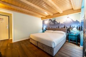 - une chambre avec un lit orné d'une fresque murale représentant la montagne dans l'établissement B&B Nonna Costantina, à Chiavenna