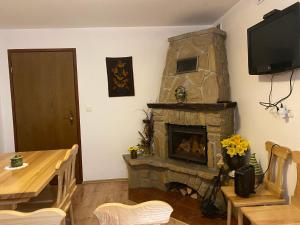 ザコパネにあるKuncówkaの石造りの暖炉とテーブル付きのリビングルーム