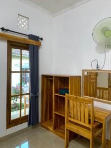 um quarto com um banco de madeira e uma janela em Penginapan Sedap Malam em Lovina