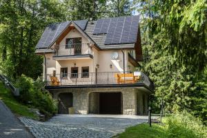 une maison avec des panneaux solaires sur le toit dans l'établissement TatryTop Alpejski SPA, à Kościelisko