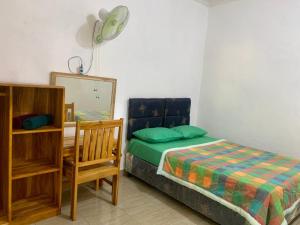 um quarto com uma cama, um espelho e uma cadeira em Penginapan Sedap Malam em Lovina
