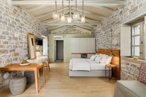 a bedroom with a bed and a brick wall at Trapela Limeni Luxury Suites in Limeni