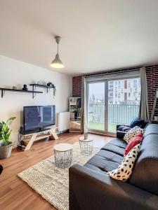 a living room with a couch and a flat screen tv at Grand Appart Renové centre ville Tram Paris 6pers in Épinay-sur-Seine