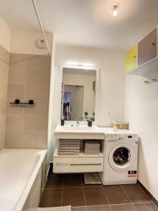 a bathroom with a washing machine and a sink at Grand Appart Renové centre ville Tram Paris 6pers in Épinay-sur-Seine