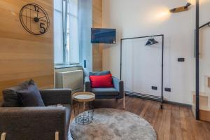 a living room with two chairs and a tv at Casa Viganò in Como