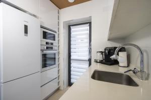 een keuken met witte werkbladen en een wastafel bij Nuez Moscada ID167 in Villamartin