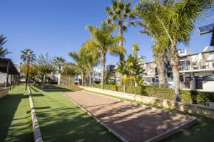 een loopbrug voor een gebouw met palmbomen bij Nuez Moscada ID167 in Villamartin