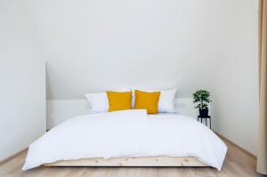 a bedroom with a white bed with yellow pillows at Jiná báseň in Pustá Rybná