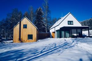 two houses in the snow with trees in the background at Jiná báseň in Pustá Rybná