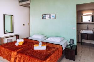 2 camas en una habitación de hotel con lavabo en Villa Aquamarine, en Pomos