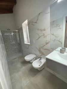 Un baño con inodoro, lavabo y ducha. en Tenuta La Torre, en Tropea