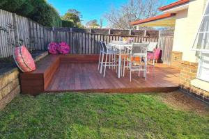 a patio with a table and chairs on a deck at Bowral Retreat in Bowral