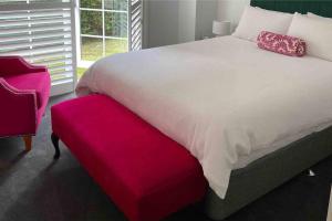 a bedroom with a large bed and a red bench at Bowral Retreat in Bowral