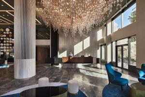 a lobby with a chandelier and tables and chairs at Grand Hyatt Athens in Athens
